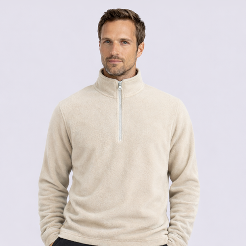 Man wearing a beige half-zip sweater on a light gray background